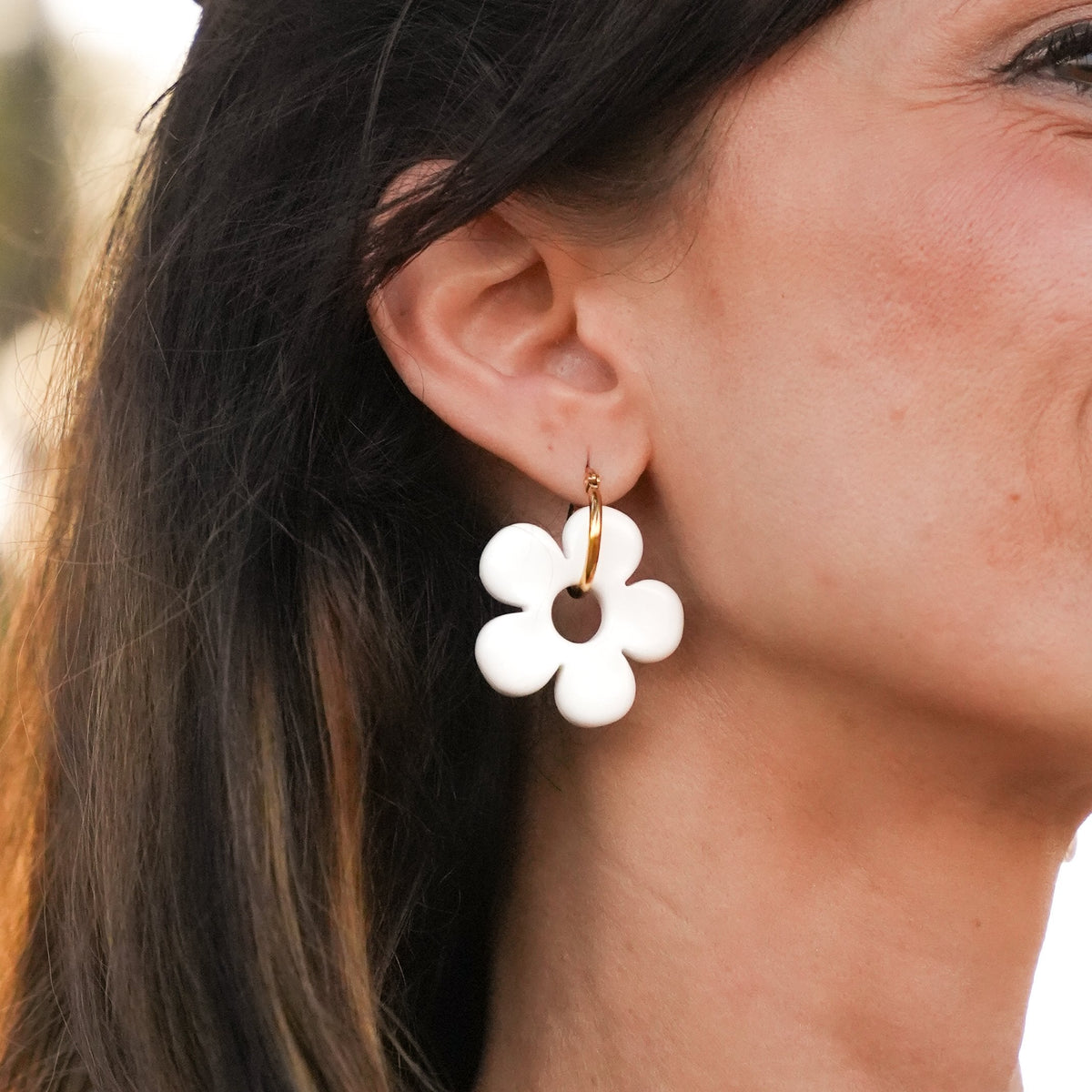 Gros plan d'un charm fleur blanche sur une créole dorée