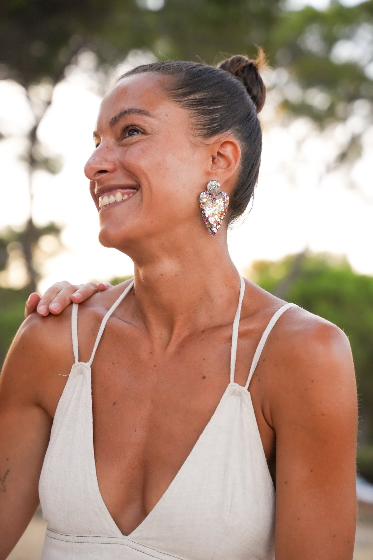 Femme portant des boucles d'oreilles coeur pailletées