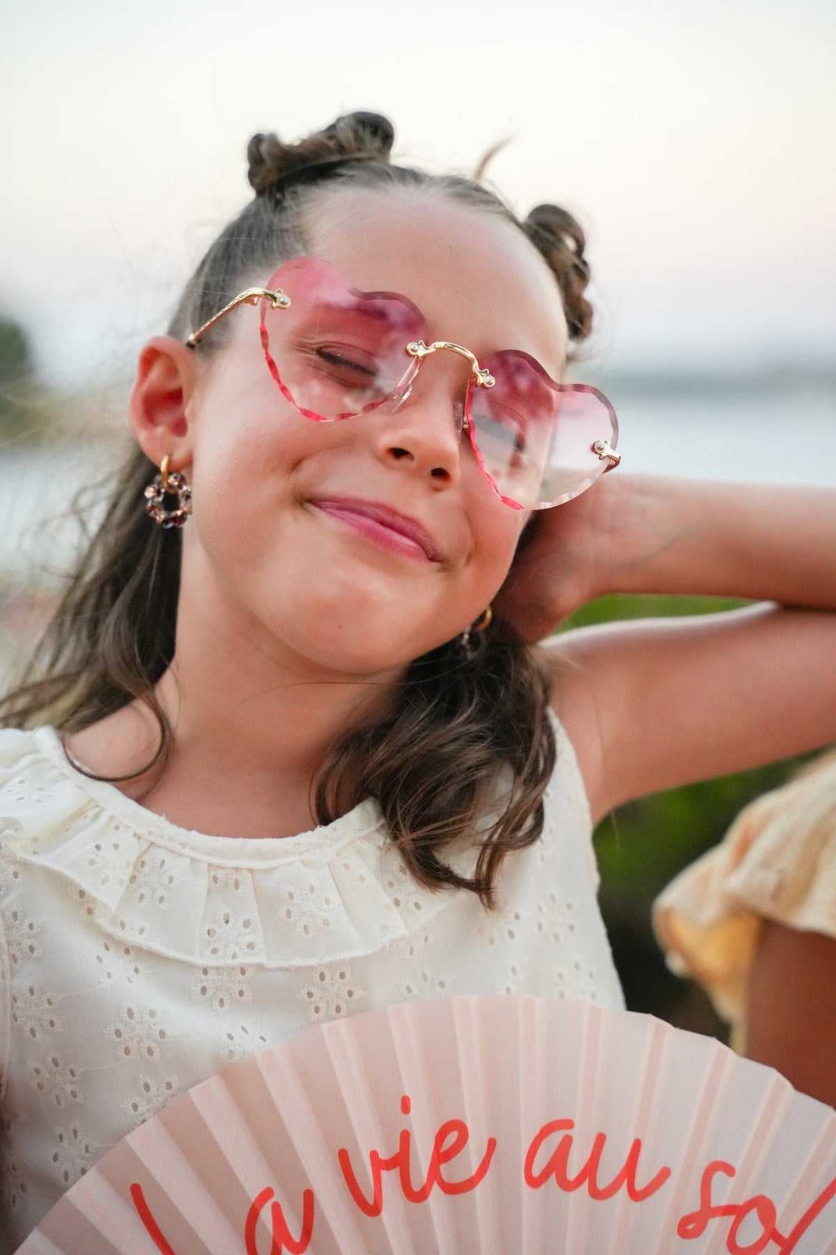 Fillette avec des lunettes coeur et une créole fleur